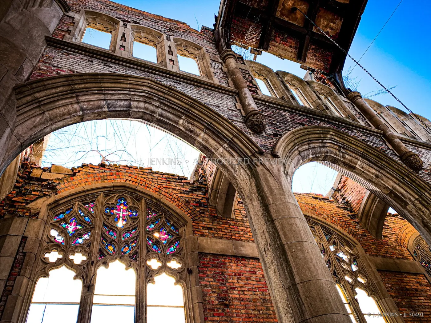 Brick and stone Gothic arches open to blue sky