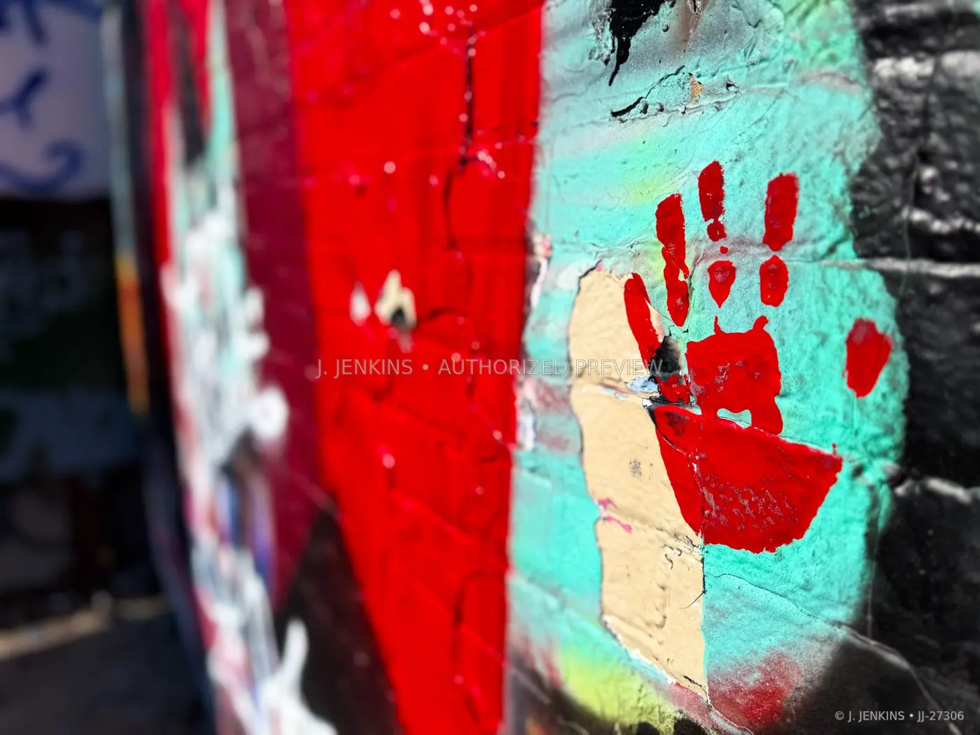 Red handprint painted on a turquoise wall