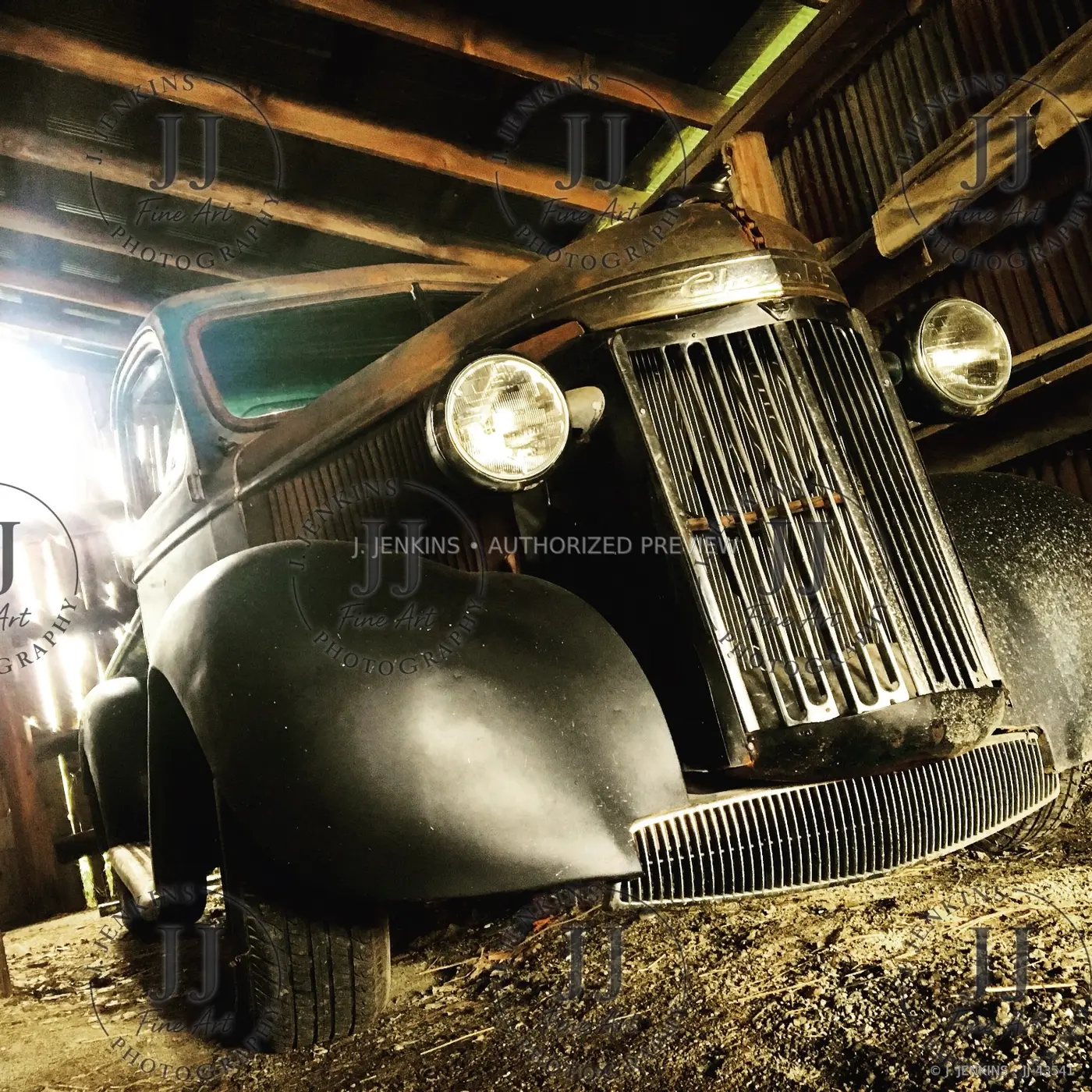 Vintage automobile emerging from a dark timber barn